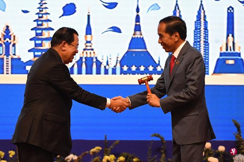 柬埔寨首相洪森与印度尼西亚总统佐科握手并将锤子交给他