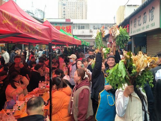 在天水市秦州区一处小院内，游客们将串串“捧花”举过头顶，有序排队品尝麻辣烫 ...